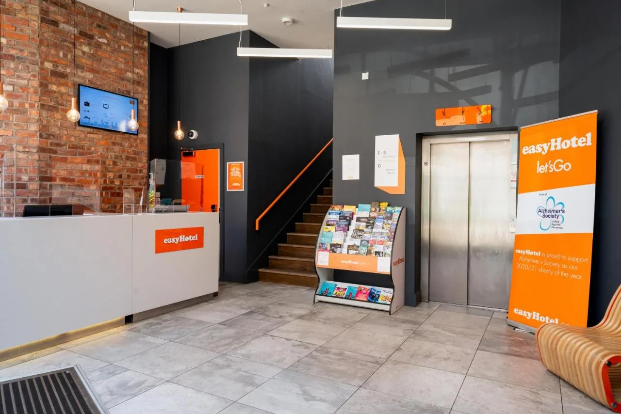 Store-style lobby with checkout counter and staircase at easyHotel Birmingham