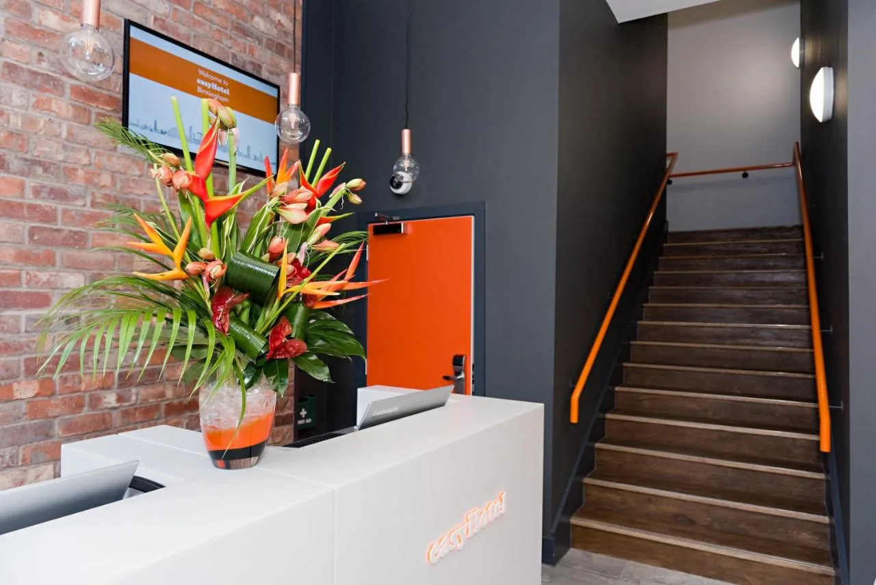 Lobby with staircase and vase of flowers at easyHotel Birmingham